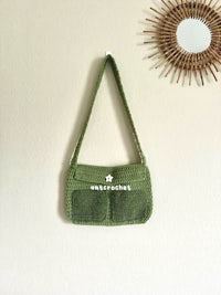 a green crocheted bag hanging on a wall
